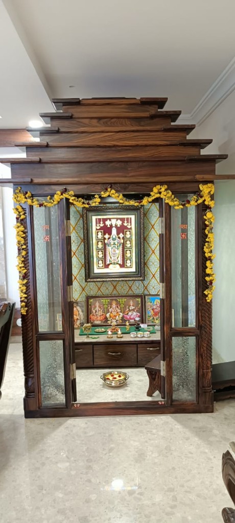 Built-in rosewood pooja room with glass doors and a stepped crown
