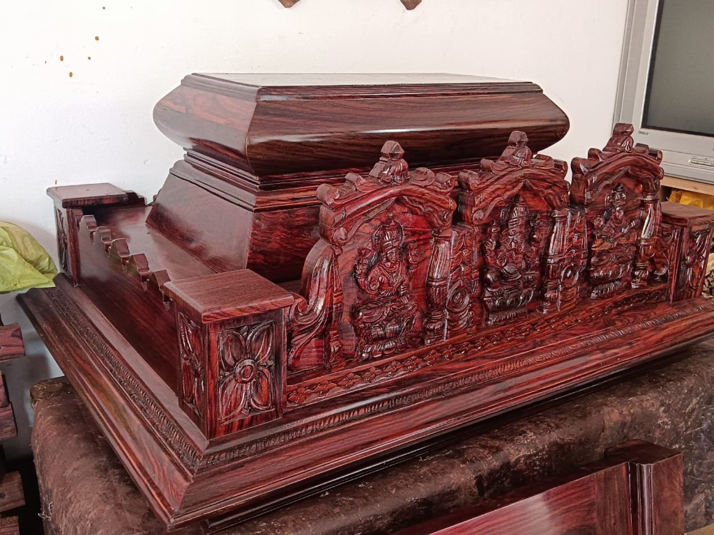 Rosewood mandir with pierced doors, an Om crest, and elephant inlay