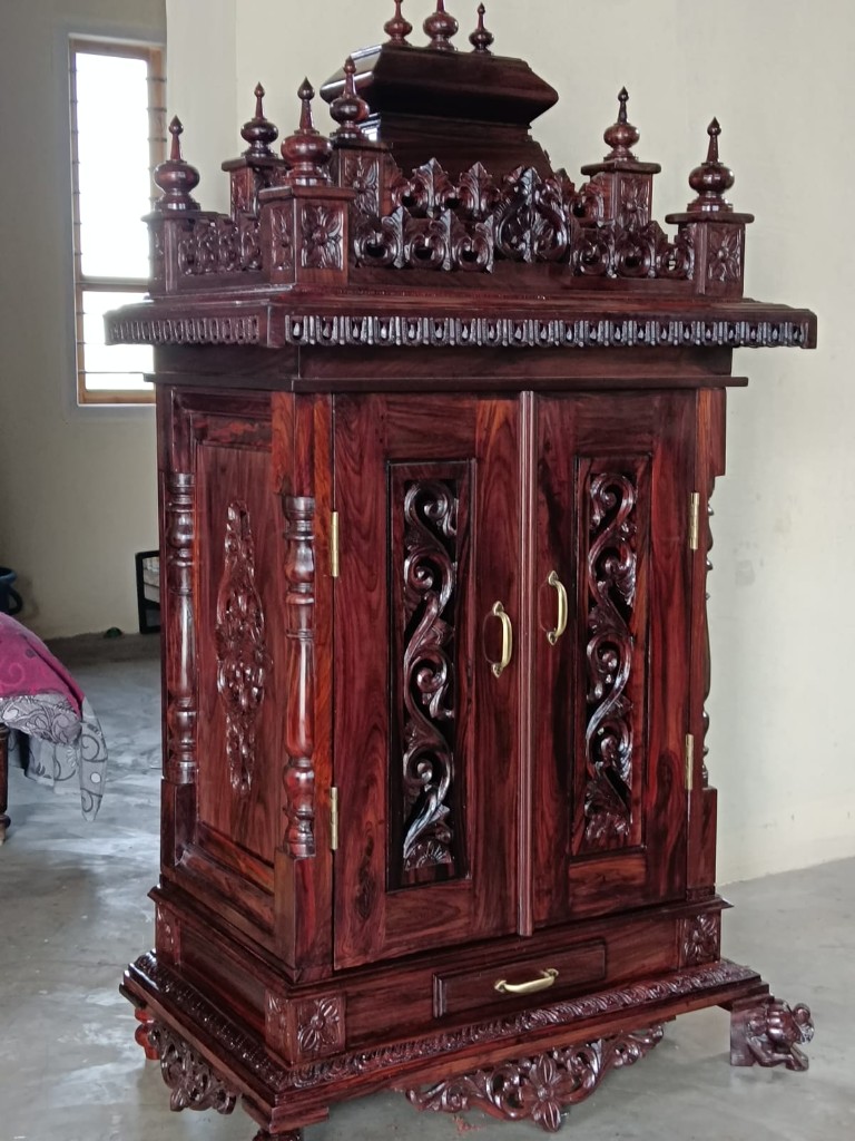 Tall rosewood cabinet with vine carvings running down the doors